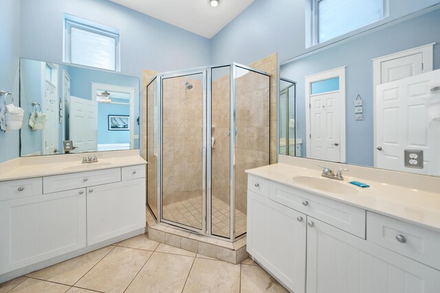 bathroom with tile patterned floors, a stall shower, and a sink