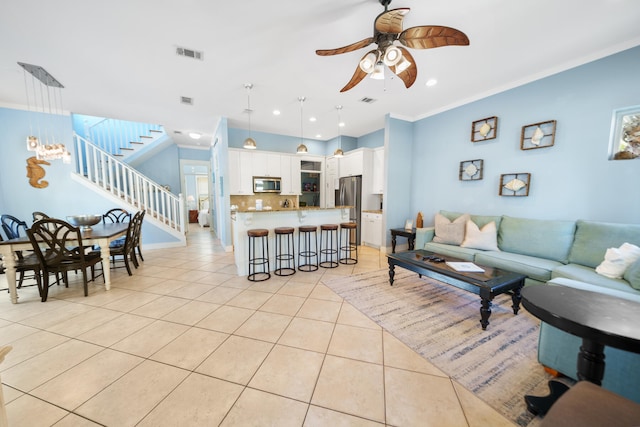 living room with ceiling fan, light tile patterned floors, and crown molding