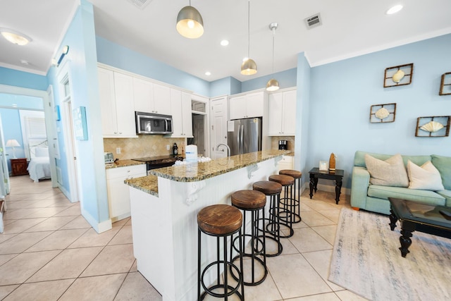 kitchen with a breakfast bar area, light tile patterned floors, visible vents, decorative backsplash, and appliances with stainless steel finishes