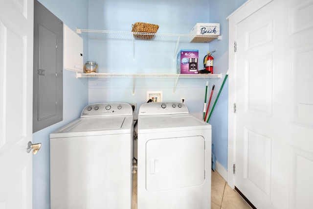 washroom with light tile patterned floors, electric panel, laundry area, and washer and clothes dryer