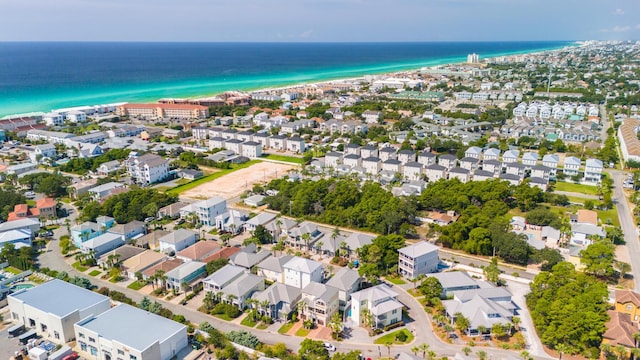 drone / aerial view featuring a residential view, a beach view, and a water view