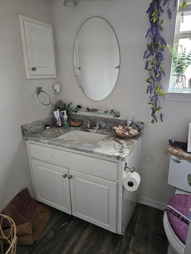 bathroom with wood-type flooring, toilet, and vanity