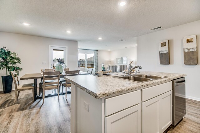 6324 Firefly Dr, Milton, FL 32583 - kitchen featuring a sink, light wood-style flooring, light countertops, a textured ceiling, and white cabinetry