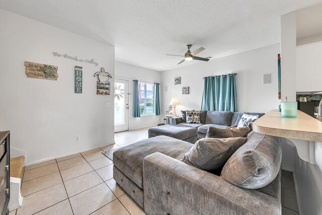 tiled living room with ceiling fan and a textured ceiling