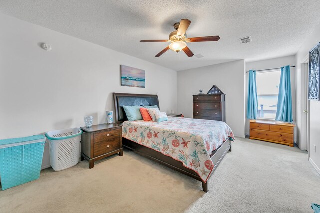 carpeted bedroom featuring a textured ceiling and ceiling fan