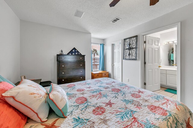 bedroom featuring a textured ceiling, connected bathroom, light tile patterned flooring, and ceiling fan