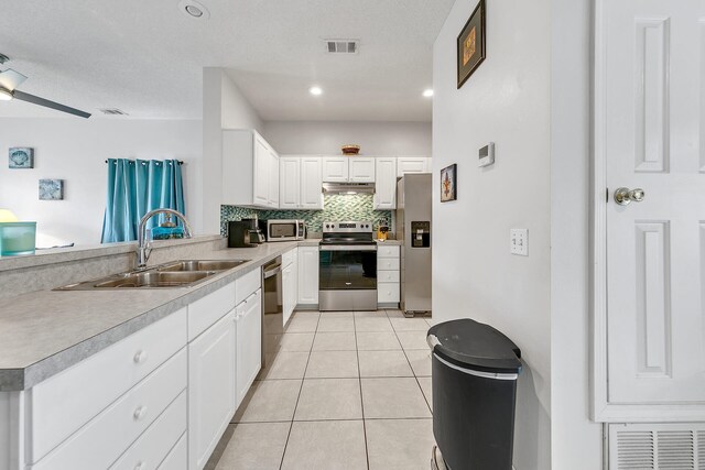 kitchen featuring sink, white cabinets, appliances with stainless steel finishes, light tile patterned floors, and ceiling fan