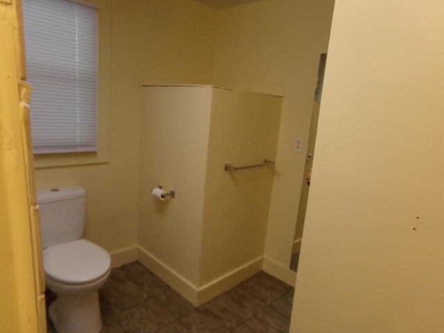 bathroom with toilet and tile patterned flooring