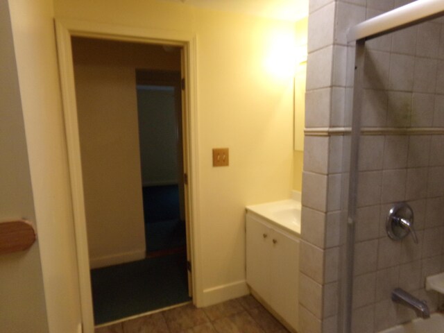 bathroom featuring vanity, tile patterned floors, and walk in shower