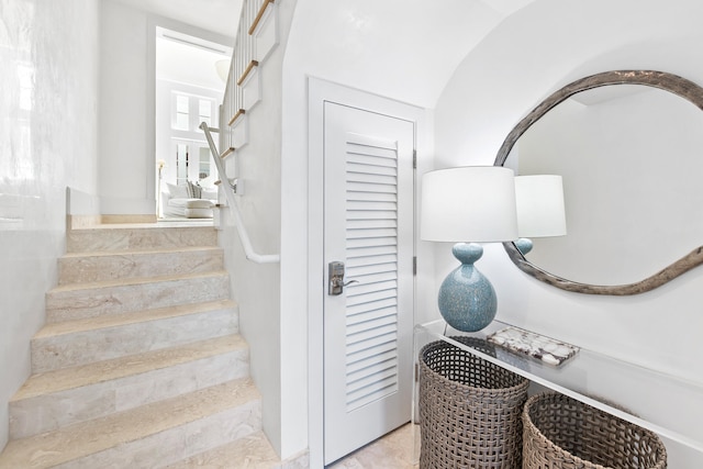 stairway featuring lofted ceiling