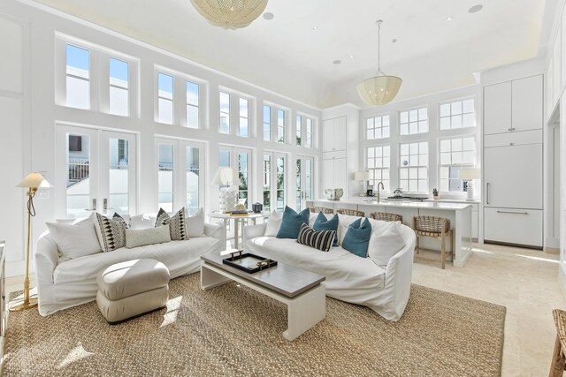 living room with a high ceiling, french doors, and sink