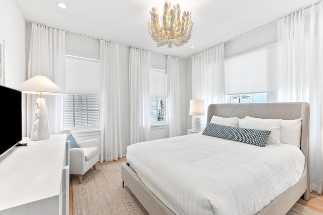 bedroom with light wood-type flooring and a chandelier