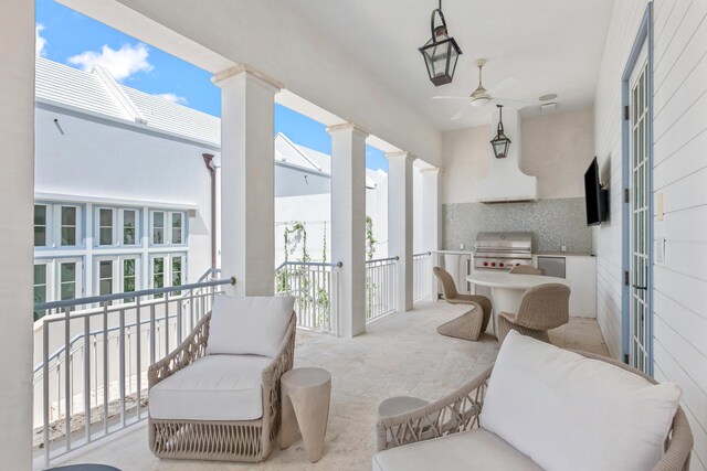 balcony featuring area for grilling, ceiling fan, and exterior kitchen