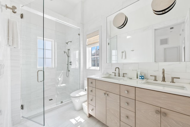 bathroom with decorative backsplash, vanity, a shower with door, toilet, and plenty of natural light