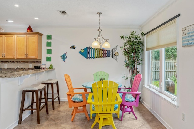 dining space featuring ornamental molding, a wealth of natural light, a notable chandelier, and light tile patterned flooring