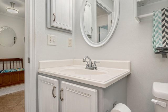 bathroom featuring toilet, vanity, tile patterned floors, and ornamental molding