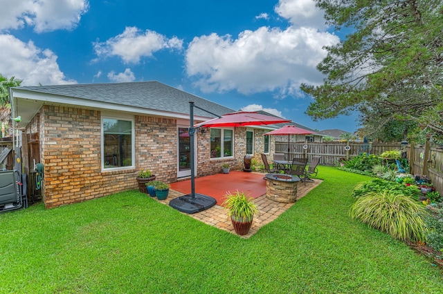 rear view of house featuring a lawn, a patio, and a fire pit