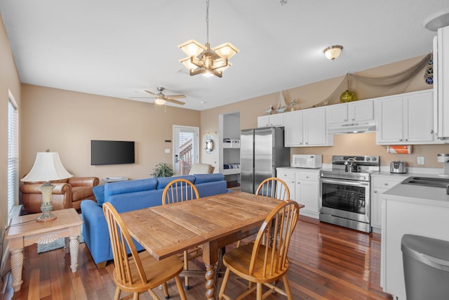 dining room featuring sink, dark hardwood / wood-style floors, and ceiling fan with notable chandelier