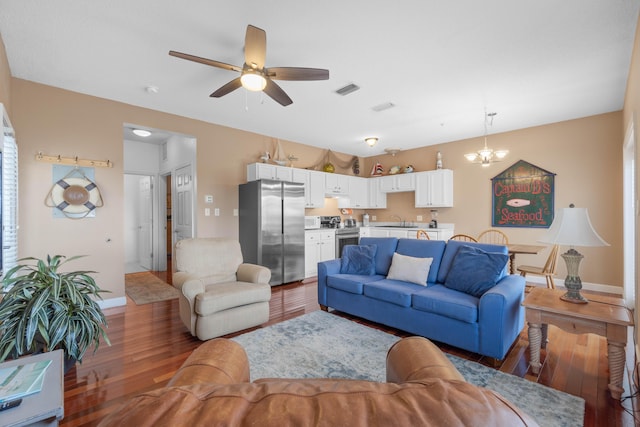 living room featuring sink, ceiling fan with notable chandelier, and wood-type flooring