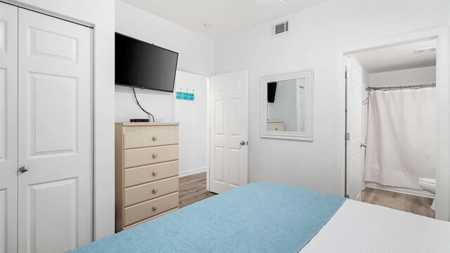 bedroom featuring connected bathroom, a closet, and light wood-type flooring