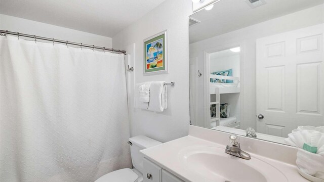 bathroom with vanity, toilet, and a shower with shower curtain