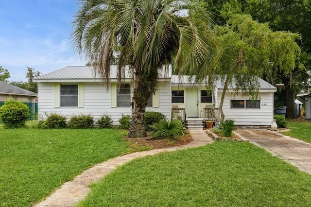 single story home featuring metal roof and a front lawn