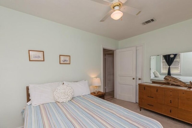 bedroom with ceiling fan, visible vents, and light carpet