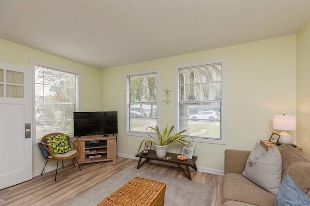 living area with baseboards and wood finished floors