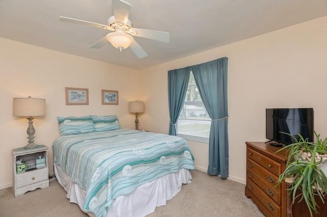 carpeted bedroom with ceiling fan and baseboards