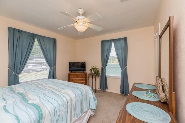 bedroom with multiple windows, a ceiling fan, and carpet flooring