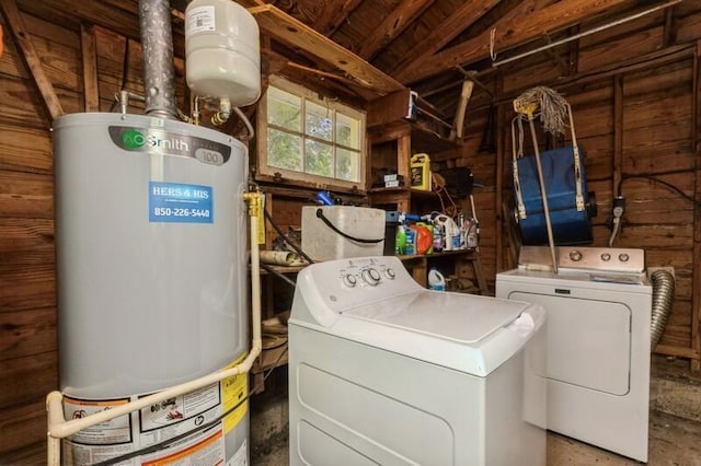 clothes washing area with independent washer and dryer, laundry area, water heater, and wood walls