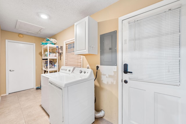 washroom featuring light tile patterned floors, electric panel, cabinets, washer and clothes dryer, and a textured ceiling