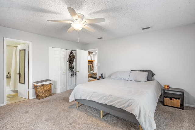 carpeted bedroom featuring a textured ceiling, ceiling fan, and connected bathroom