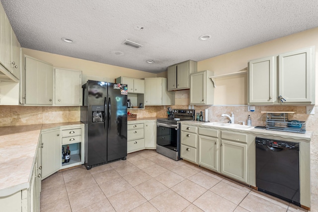 kitchen with cream cabinetry, black appliances, a textured ceiling, and sink