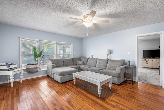 living room featuring ceiling fan, wood-type flooring, and a textured ceiling