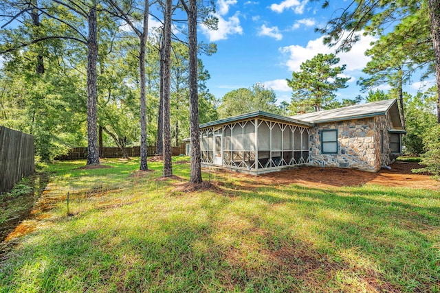 rear view of house with a sunroom and a yard