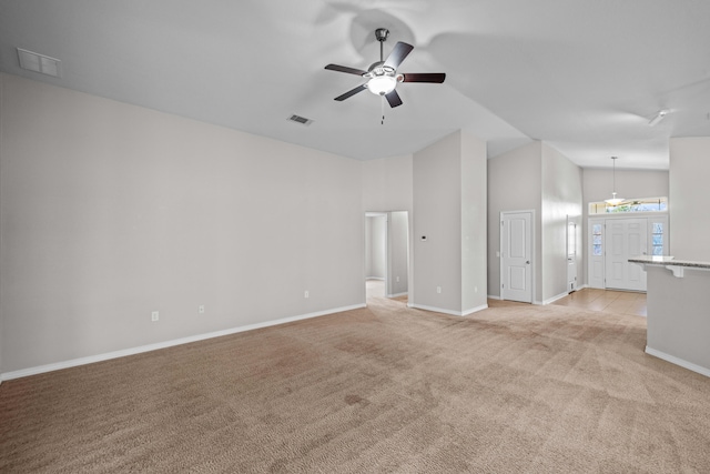 unfurnished living room with ceiling fan, light colored carpet, and high vaulted ceiling