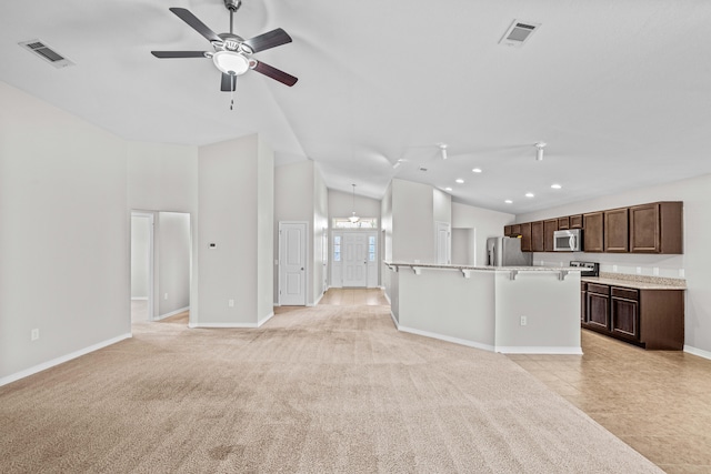 unfurnished living room with ceiling fan, light tile patterned floors, and high vaulted ceiling