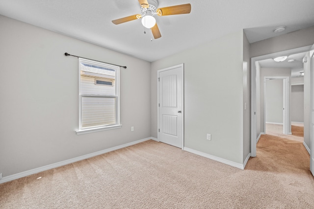 unfurnished bedroom featuring ceiling fan and light carpet