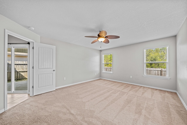 carpeted empty room with ceiling fan and a textured ceiling