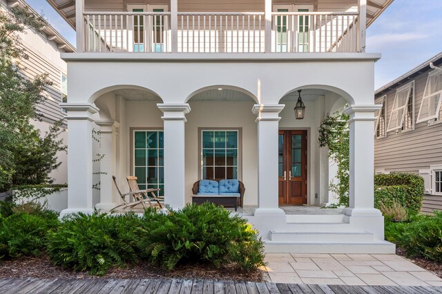 entrance to property featuring a porch and a balcony