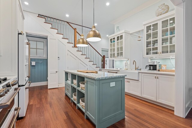 kitchen with decorative light fixtures, a kitchen island, dark hardwood / wood-style flooring, and white cabinetry