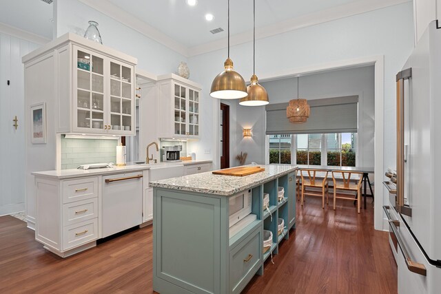 kitchen with white appliances, dark hardwood / wood-style flooring, pendant lighting, a center island, and white cabinets