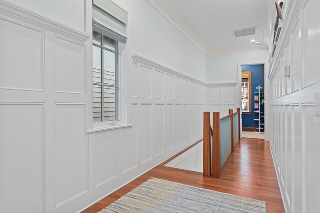 corridor with hardwood / wood-style floors and crown molding