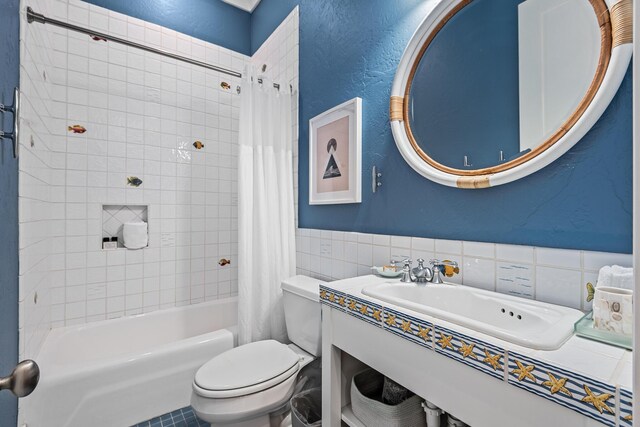 full bathroom with toilet, sink, tile walls, shower / tub combo, and decorative backsplash