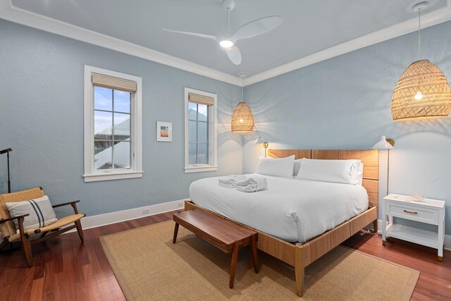 bedroom with ornamental molding, dark hardwood / wood-style flooring, and ceiling fan