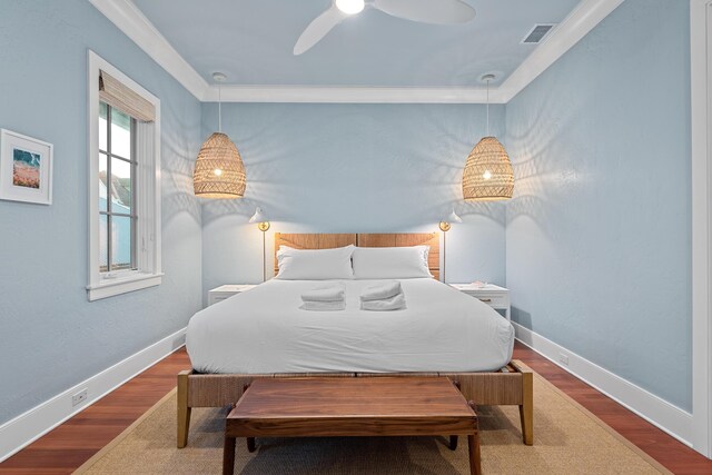 bedroom with dark wood-type flooring, ceiling fan, and ornamental molding