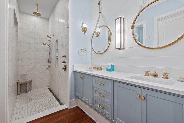 bathroom featuring vanity, a tile shower, and wood-type flooring