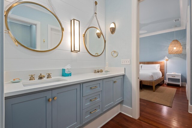 bathroom with hardwood / wood-style flooring, ornamental molding, and vanity