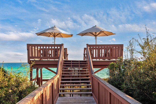 surrounding community featuring a deck with water view